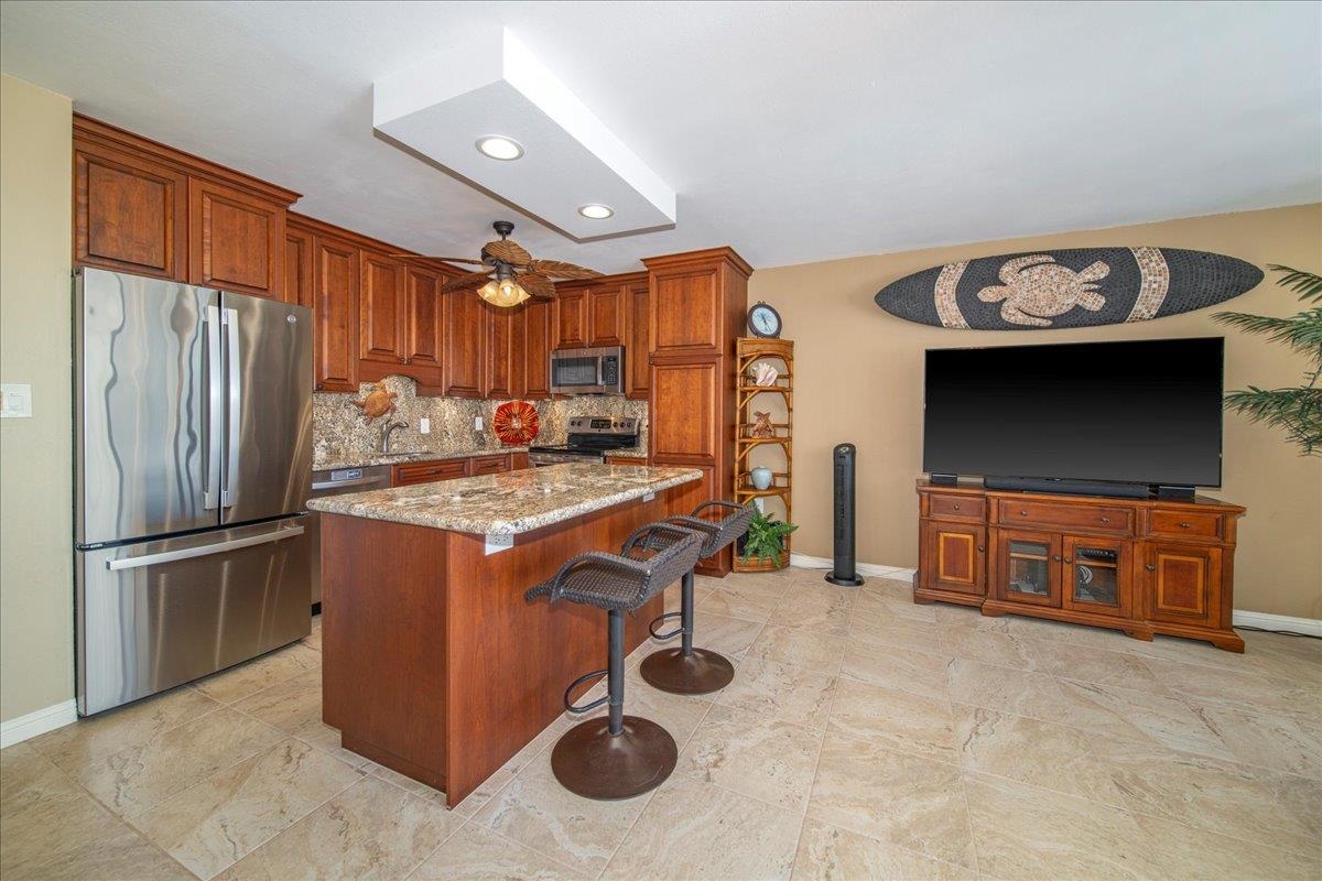 2387 South Kihei Road, Unit B303 Kihei, HI 96753 - Photo 9 of 48 a kitchen with stainless steel appliances granite countertop a stove refrigerator and microwave