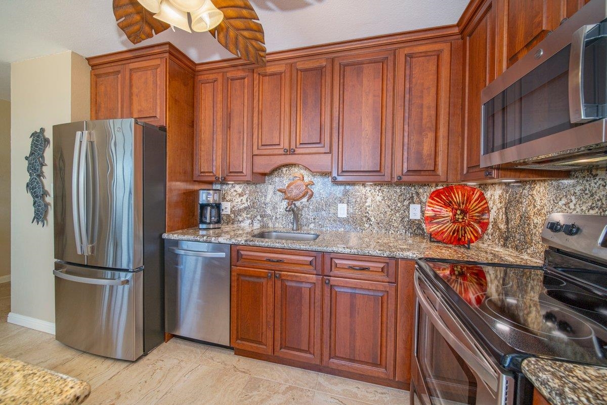 2387 South Kihei Road, Unit B303 Kihei, HI 96753 - Photo 10 of 48 a kitchen with stainless steel appliances granite countertop a refrigerator and a stove top oven