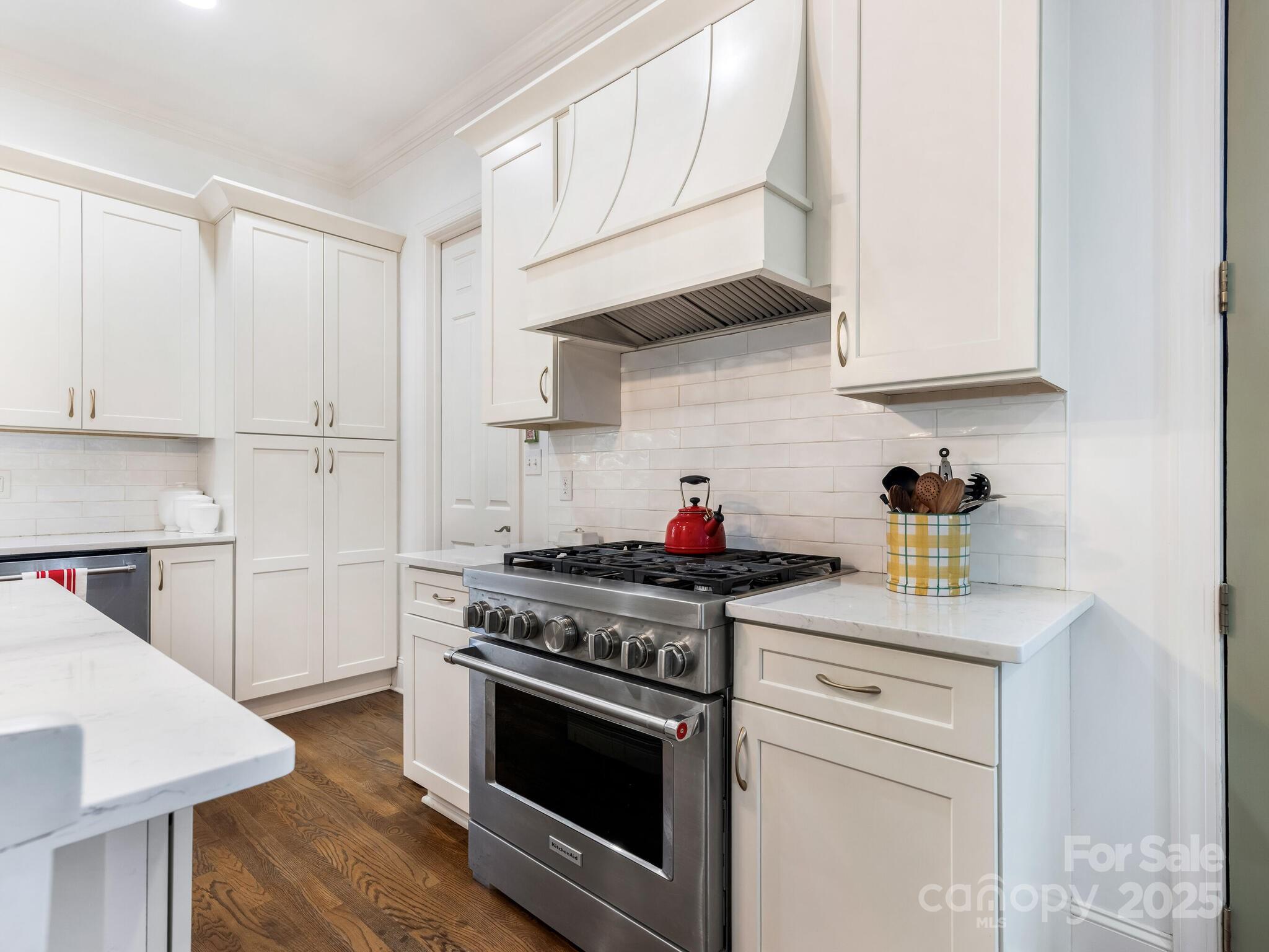1110 Princeton Avenue Charlotte, NC 28209 - Photo 13 of 29 a kitchen with stainless steel appliances granite countertop a sink a stove and white cabinets