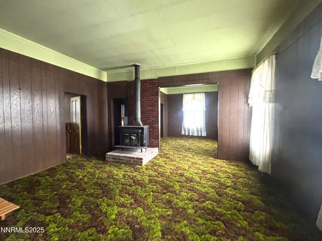 a view of a livingroom with wooden floor and kitchen space