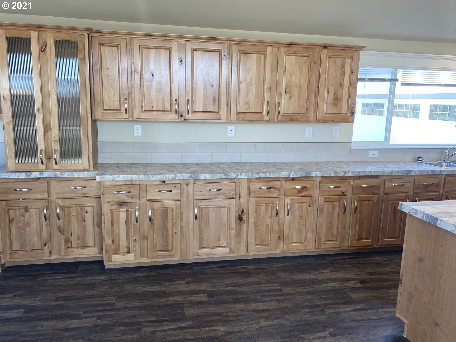 305 Oregon Trail Boulevard Boardman, OR 97818 - Photo 3 of 11 a kitchen with granite countertop wooden cabinets a sink and dishwasher with wooden floor