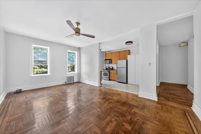 a view of a livingroom with wooden floor and a ceiling fan