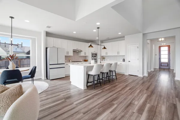 a kitchen with a sink stove and wooden floor