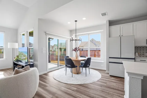a living room with kitchen island furniture wooden floor and a view of kitchen