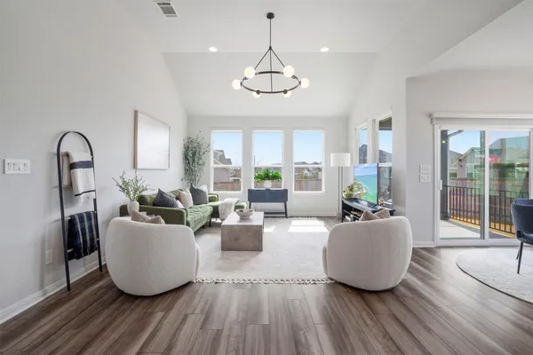 a dining room with furniture a chandelier and wooden floor