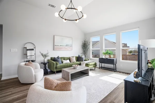 a living room with furniture a window and wooden floor
