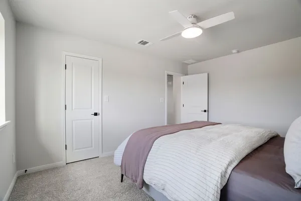 a bedroom with a bed and a painting on the wall