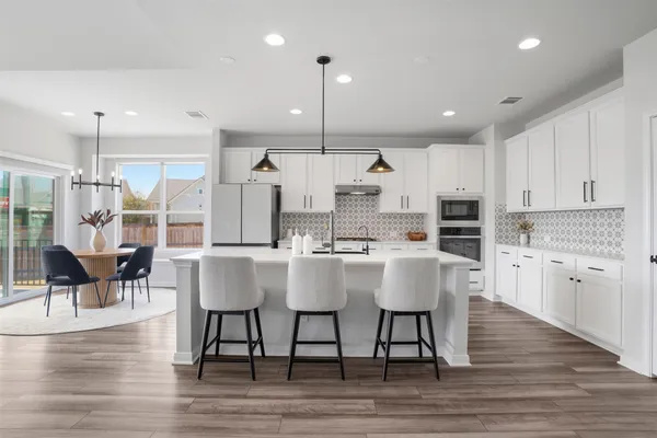 a kitchen with granite countertop white cabinets and stainless steel appliances