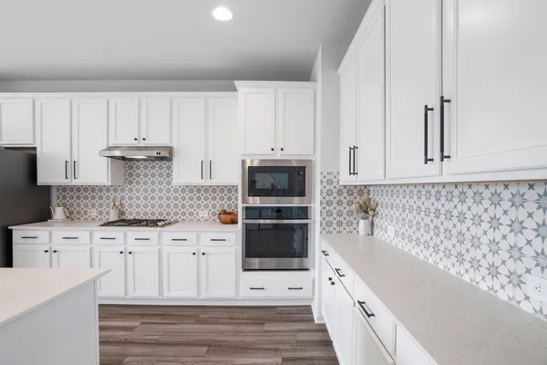 a kitchen with white cabinets appliances and sink