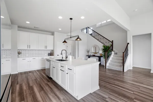 a kitchen with sink stove and cabinets