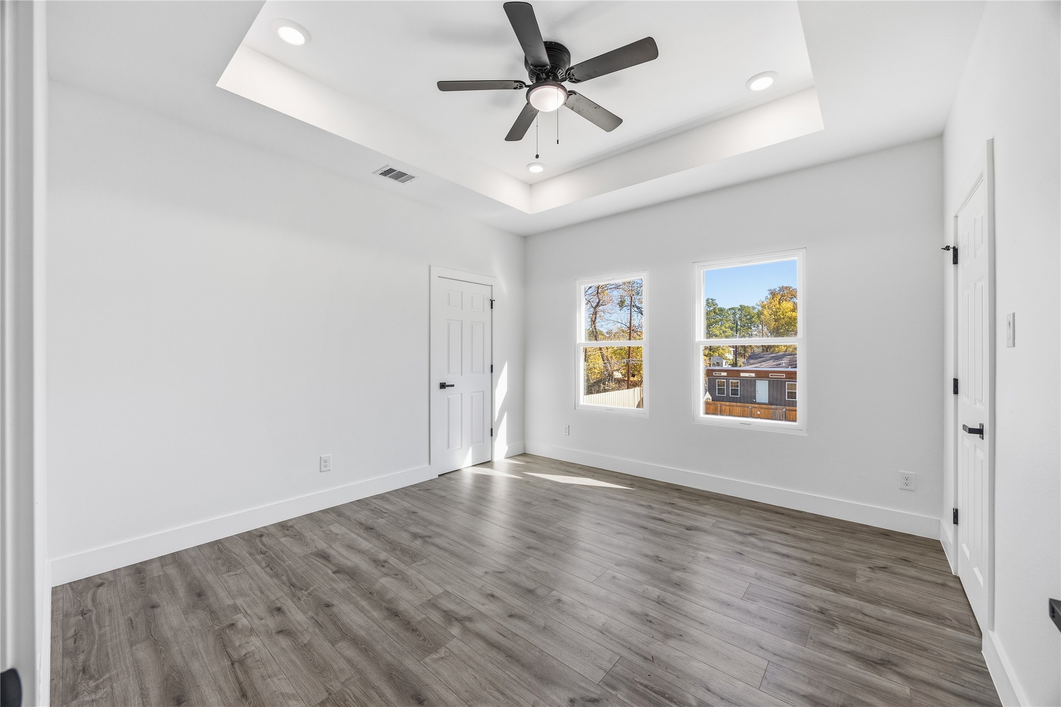 6063 Townsan Road Houston, TX 77396 - Photo 34 of 46 an empty room with wooden floor ceiling fan and windows