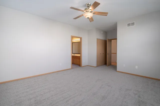 an empty room with a ceiling fan and a window