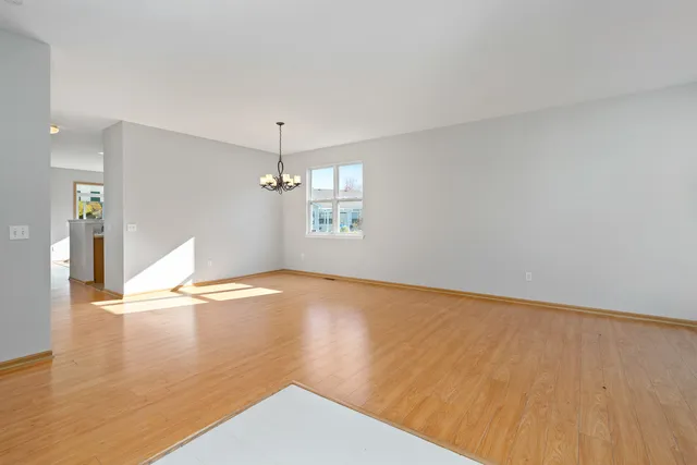a view of empty room with wooden floor and window