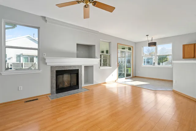 a view of empty room with wooden floor and fireplace