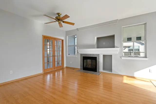 a view of empty room with fireplace and wooden floor