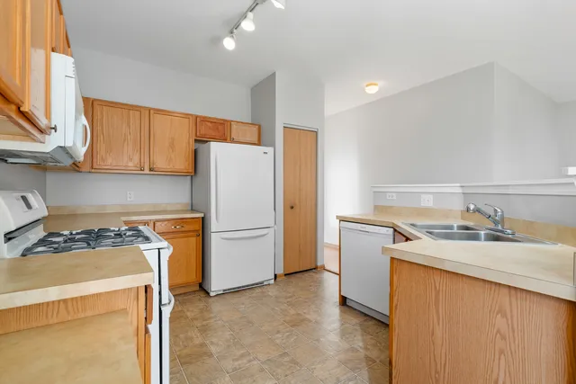 a utility room with refrigerator sink washer and dryer