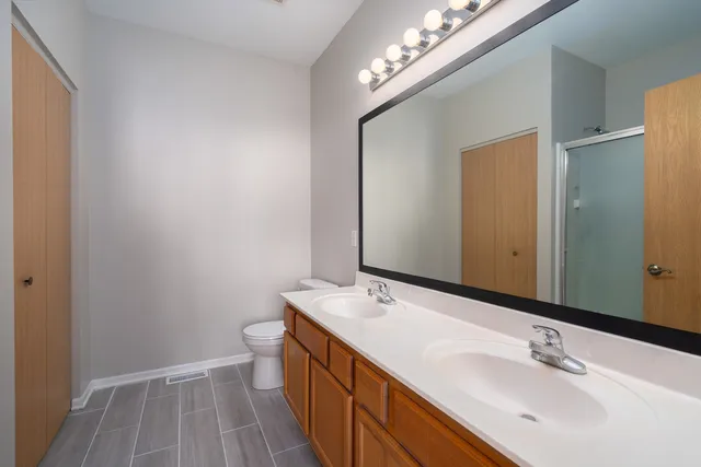a bathroom with a sink a toilet and a large mirror