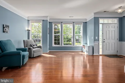 a view of a livingroom with furniture wooden floor and windows