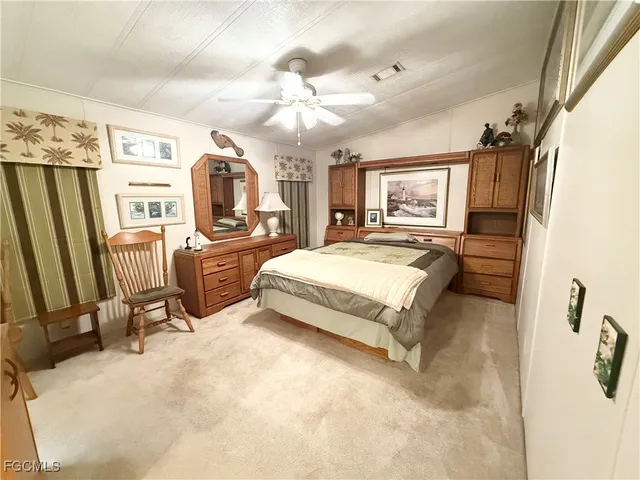 a spacious bedroom with a bed a flat screen tv and chandelier