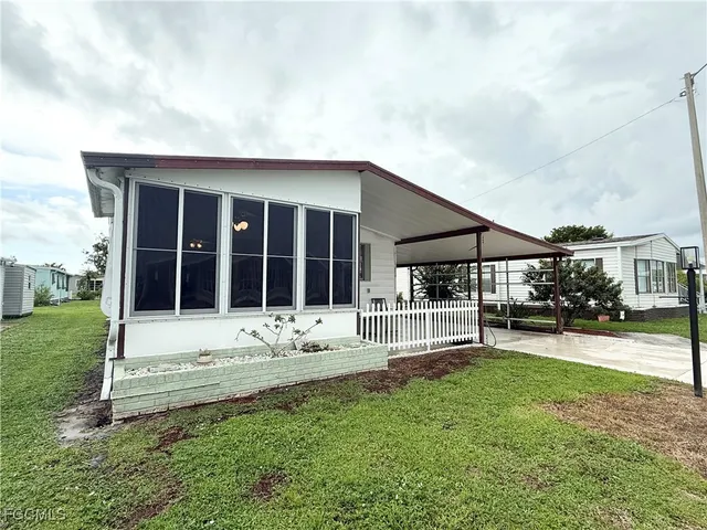 a view of house with backyard and sitting area