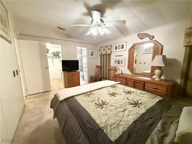 a bed room with a bed mirror on wall and a window