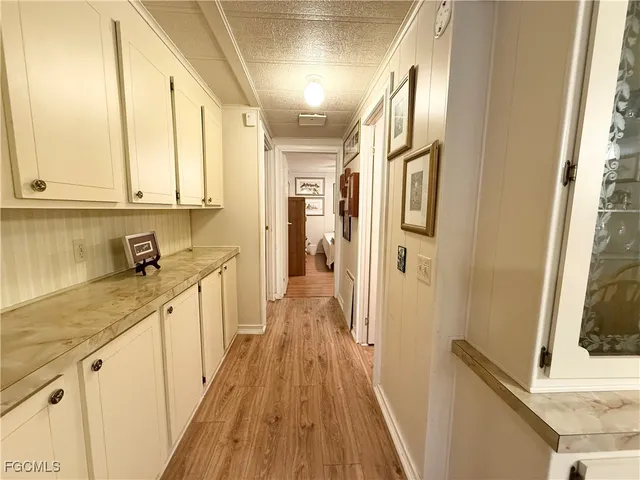 a view of a kitchen with wooden floor and cabinets