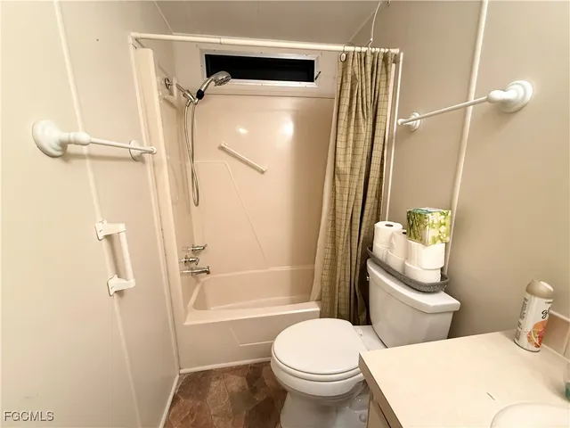 a white toilet sitting next to a bathroom sink and a shower