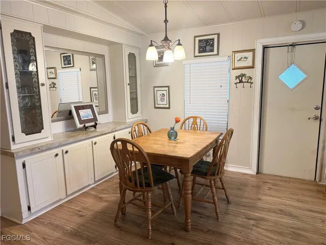 a dining room with furniture a chandelier and wooden floor