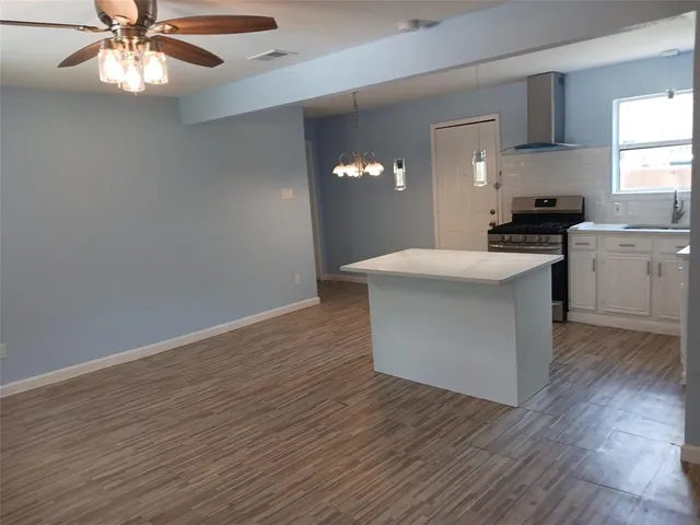 a kitchen with a chandelier and wooden floor