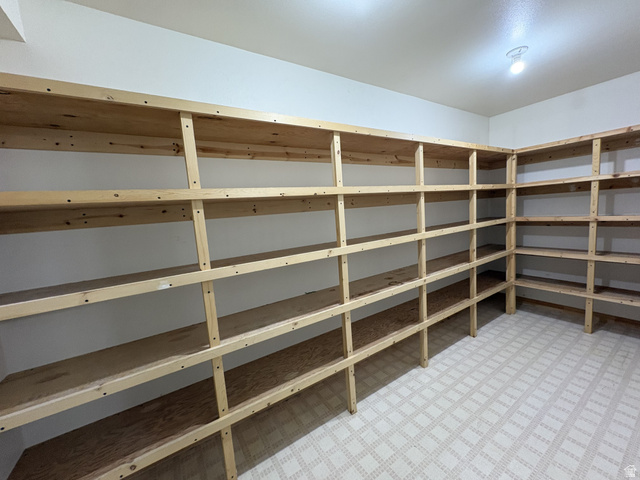 486 West 120 North Orem, UT 84057 - Photo 22 of 30 Dedicated storage room featuring extensive built-in wooden shelving, white painted walls, and patterned vinyl flooring