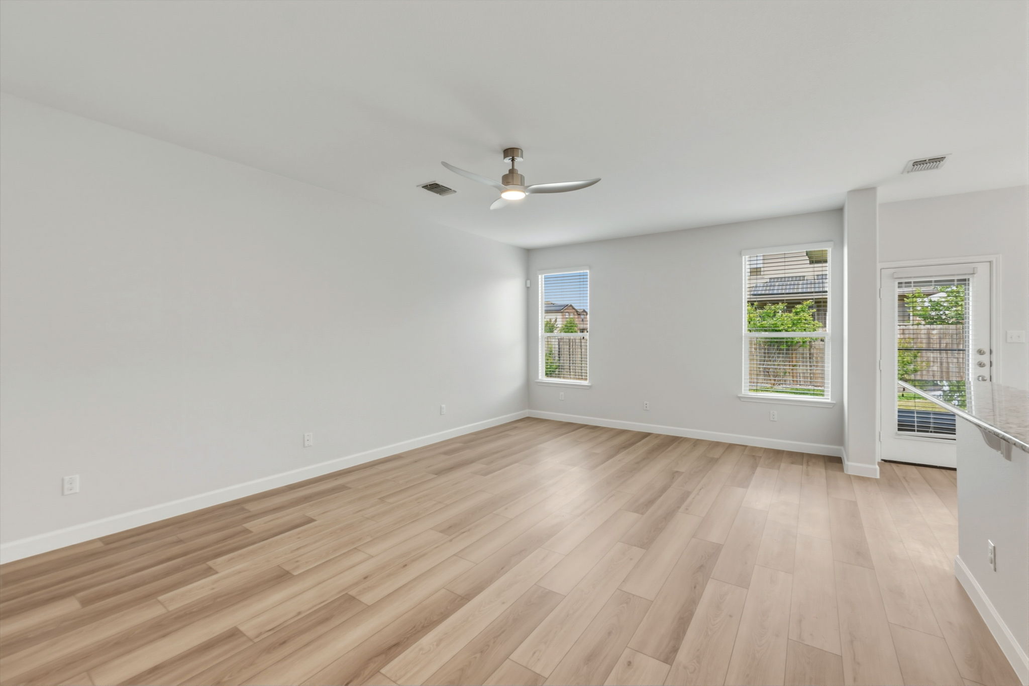 301 Serpentine Lane Jarrell, TX 76537 - Photo 11 of 39 an empty room with wooden floor chandelier fan and windows