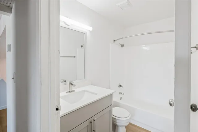 a bathroom with a granite countertop sink and a toilet