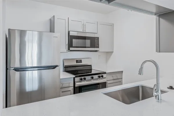 a kitchen with a refrigerator and a stove top oven