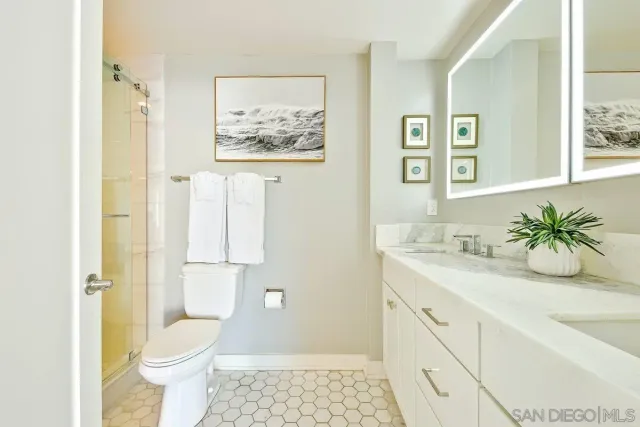 a bathroom with a granite countertop bathtub shower sink and mirror