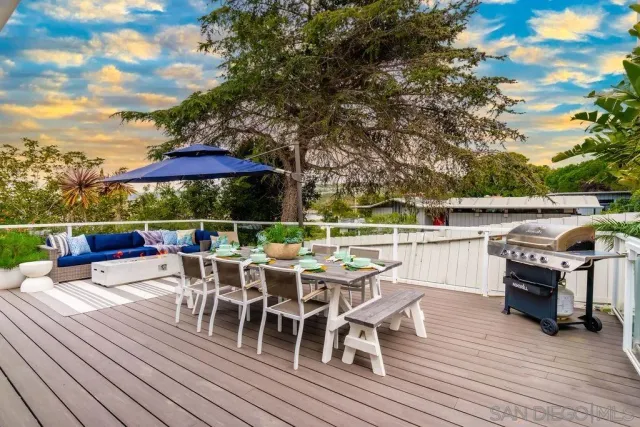 a view of a roof deck with table and chairs under an umbrella