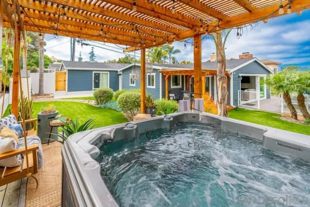a view of a house with backyard and sitting area
