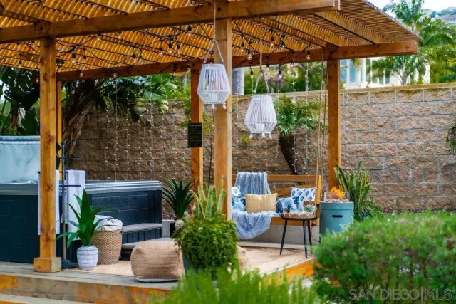 a view of a backyard with plants and large tree