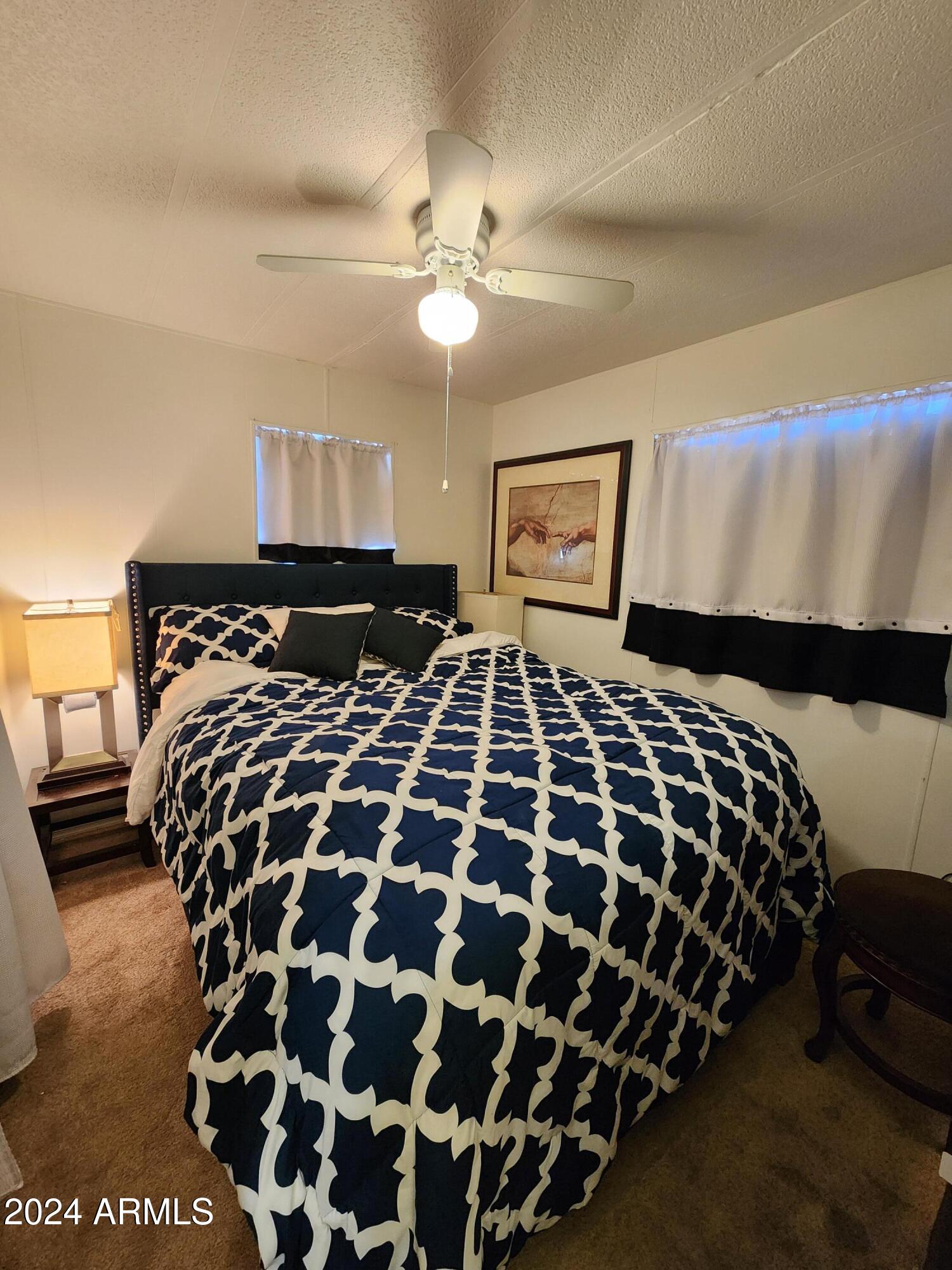 16005 North 32nd Street, Unit 33 Phoenix, AZ 85032 - Photo 15 of 40 a bedroom with a large bed and a chandelier