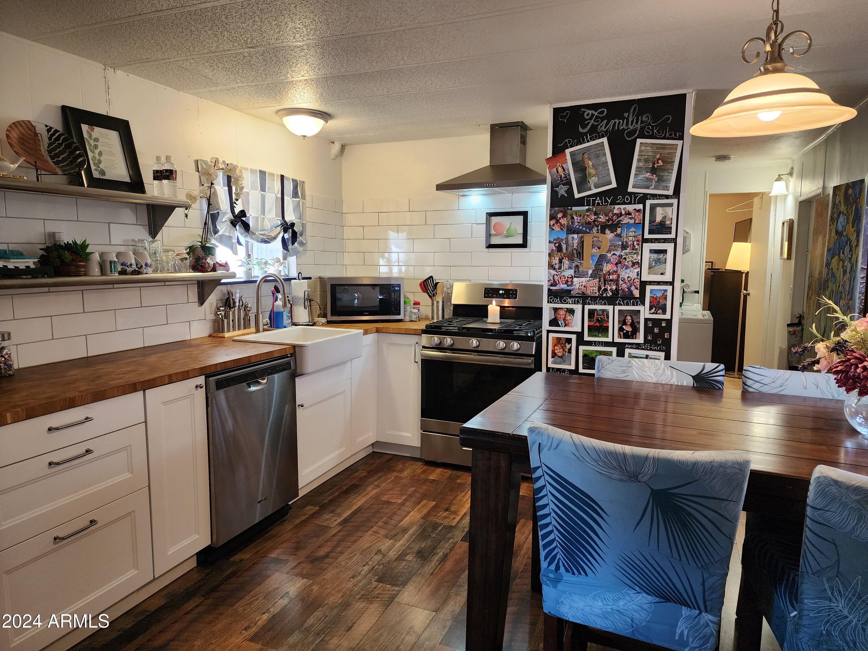 16005 North 32nd Street, Unit 33 Phoenix, AZ 85032 - Photo 5 of 40 a kitchen with stainless steel appliances granite countertop a sink a stove and chairs