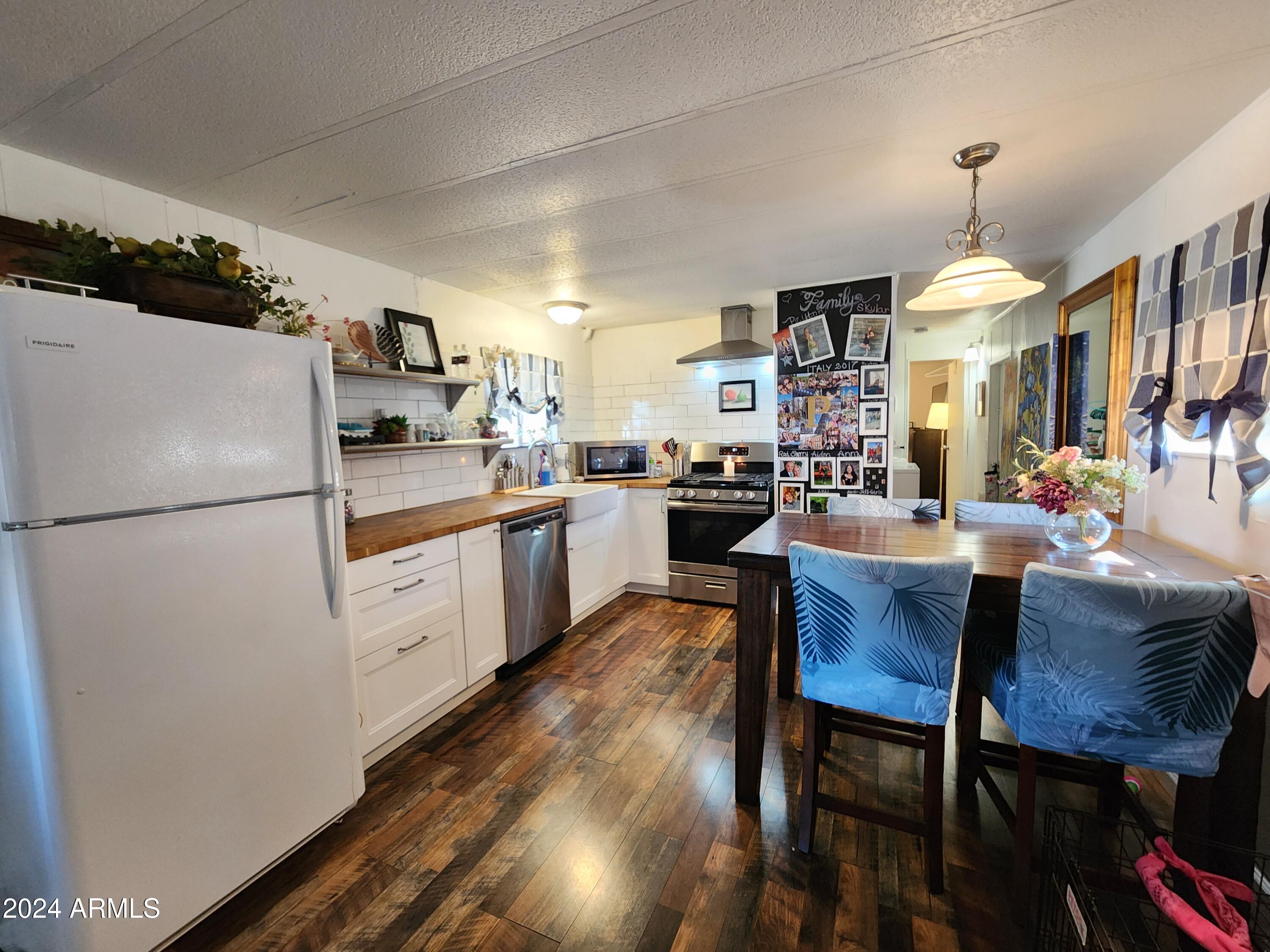 16005 North 32nd Street, Unit 33 Phoenix, AZ 85032 - Photo 6 of 40 a kitchen with refrigerator cabinets dining table and chairs