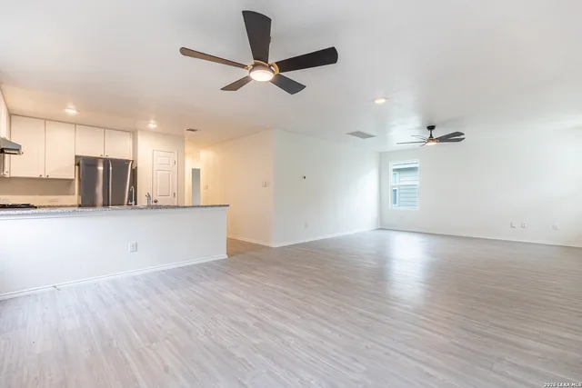 wooden floor in an empty room with a kitchen