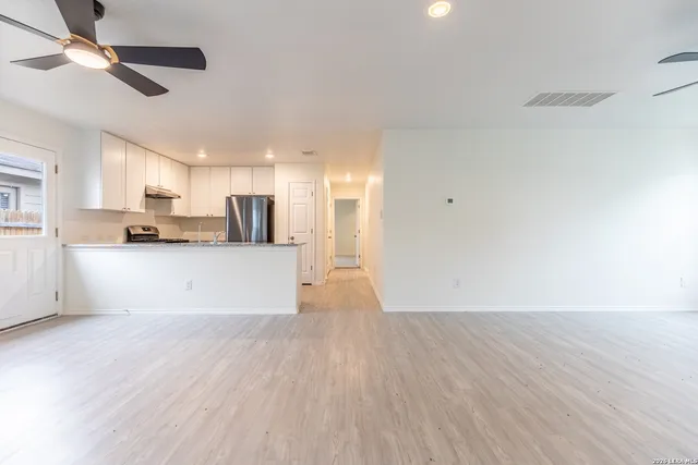 a view of a kitchen with wooden floor and a sink