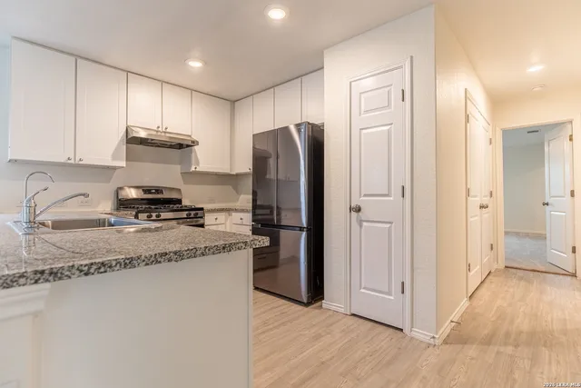 a kitchen with stainless steel appliances granite countertop a refrigerator sink and stove