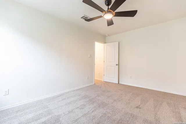 an empty room with a window and a fan