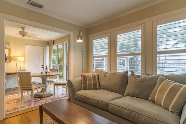 a living room with furniture a wooden floor and a large window