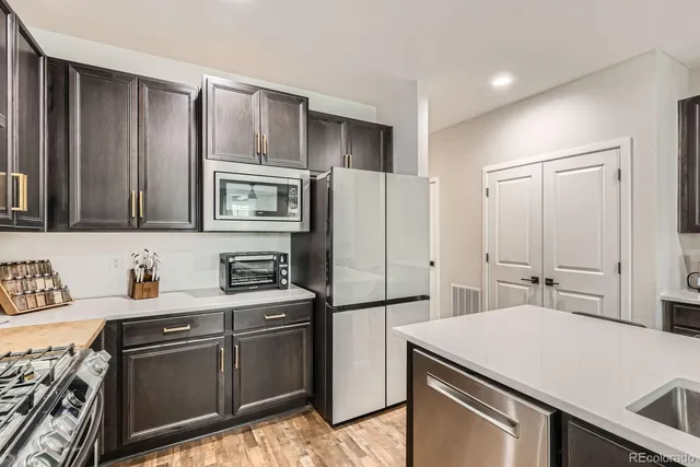 a kitchen with stainless steel appliances a refrigerator and a stove top oven