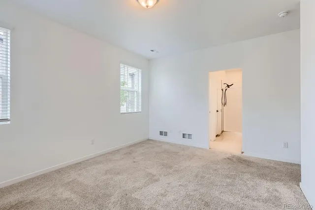 an empty room with an entryway and window