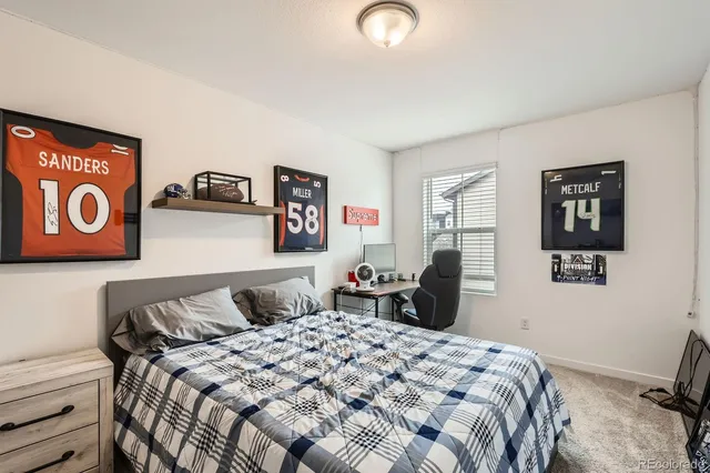 a bedroom with a bed and painting on the wall