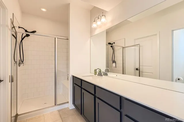 a bathroom with a shower sink vanity and mirror