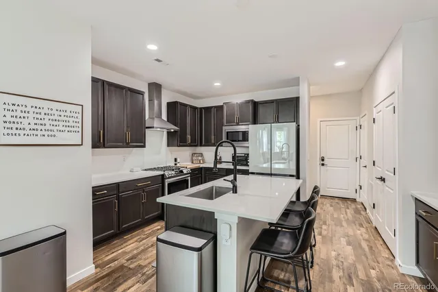 a kitchen with granite countertop a sink stove and refrigerator